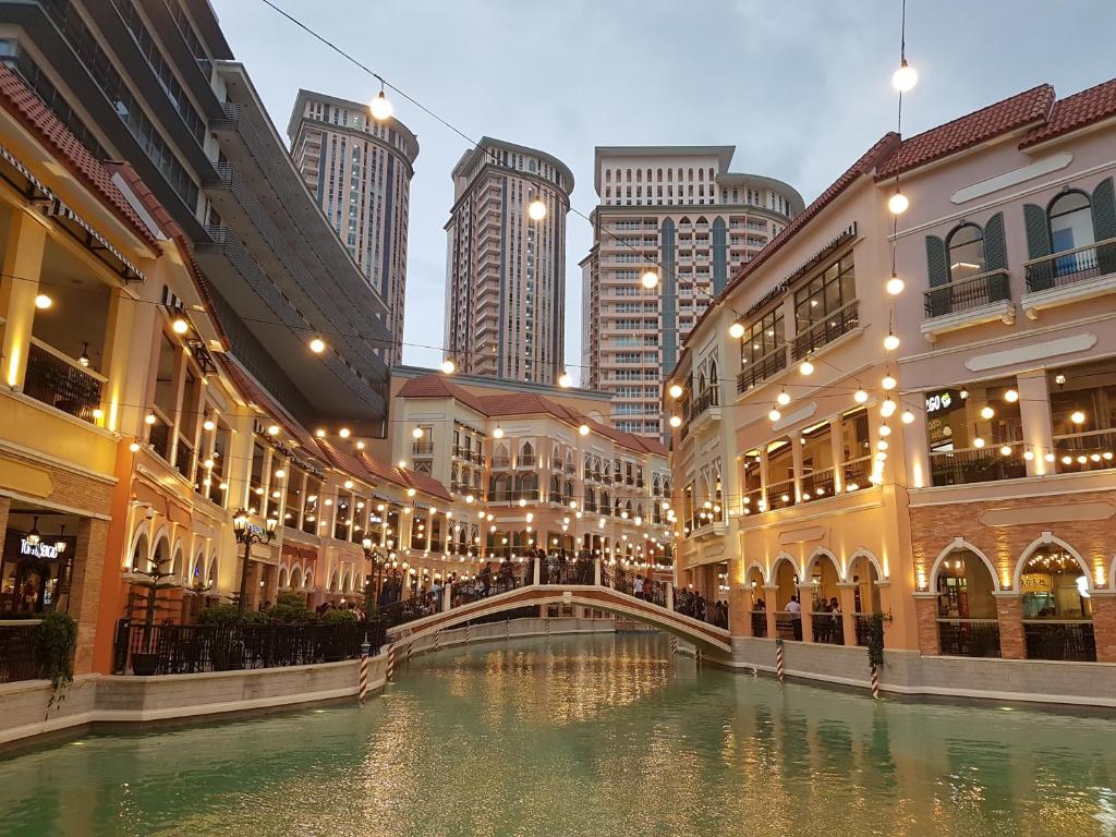 a canal in a city with buildings and a bridge at Luxe in Venice in Manila