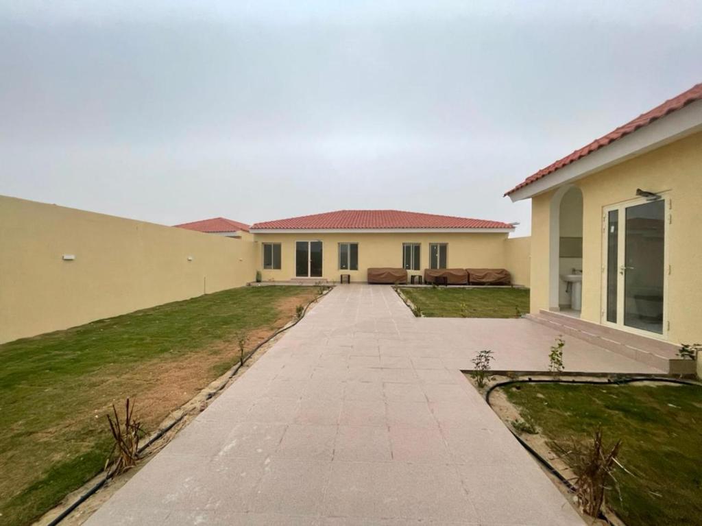 a house with a walkway in front of it at استراحة الضيافة in Al Jubail