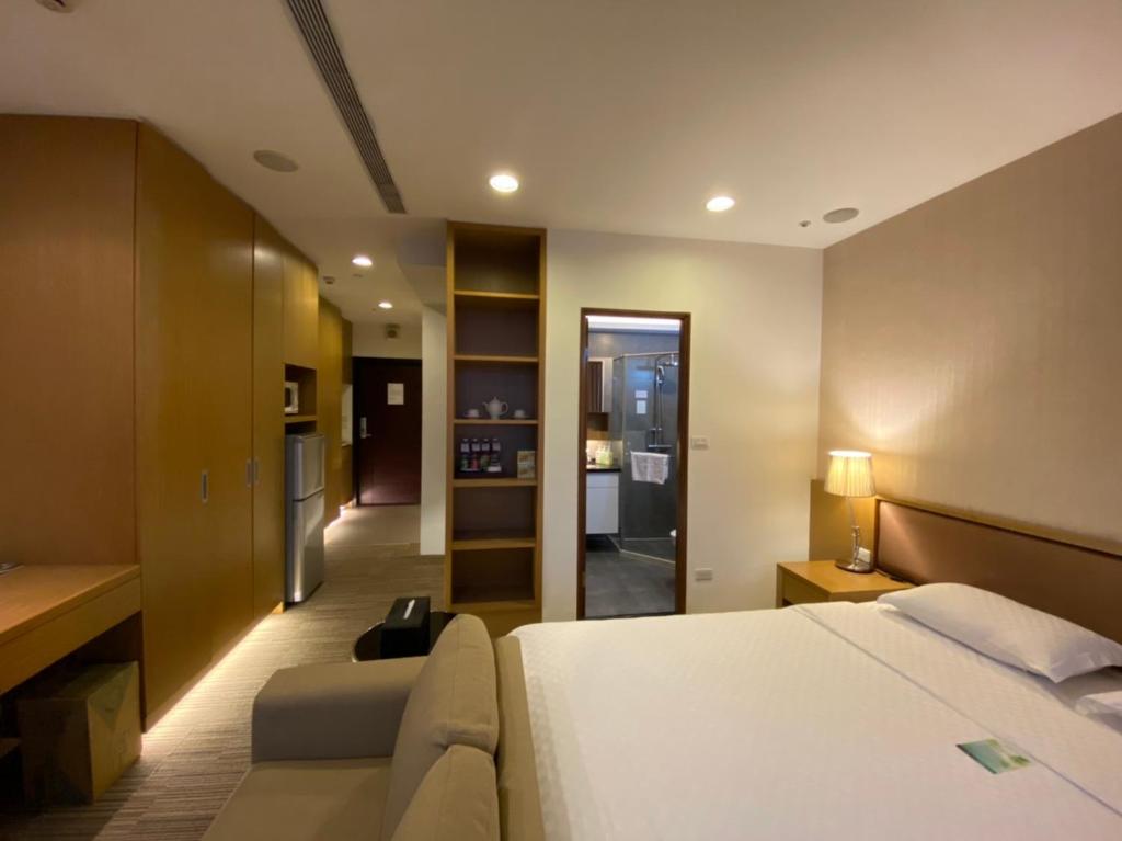 um quarto de hotel com uma cama e um sofá em AJ Residence 安捷國際公寓酒店 em Taipei