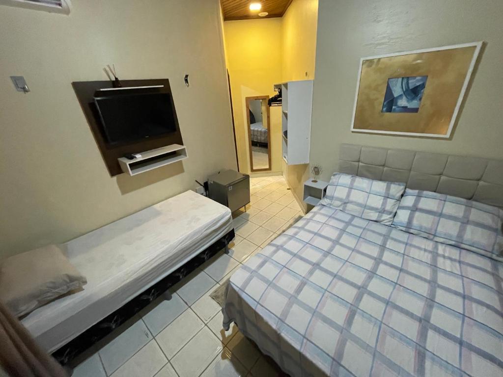 Habitación con cama y TV. en Smart Suíte en Boa Vista