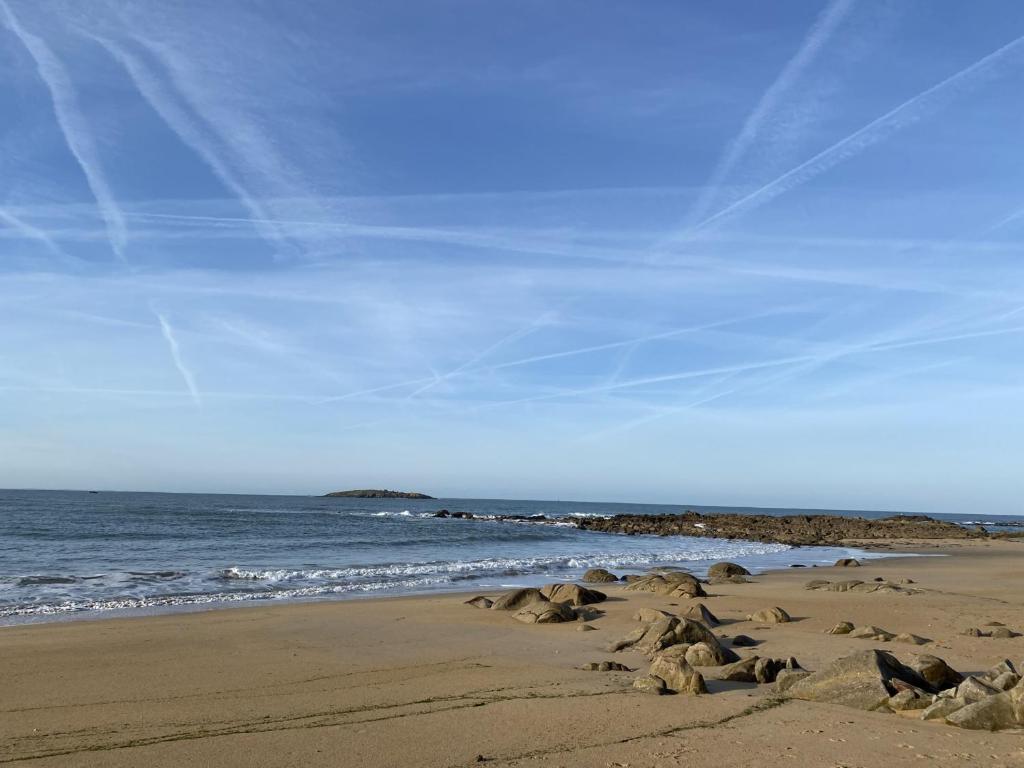 a beach with rocks in the sand and the ocean w obiekcie Charmante Maison avec Jardin et Parking Privé, à 4 km de la Plage - Idéalement Située à Erdeven - FR-1-397-70 w mieście Erdeven