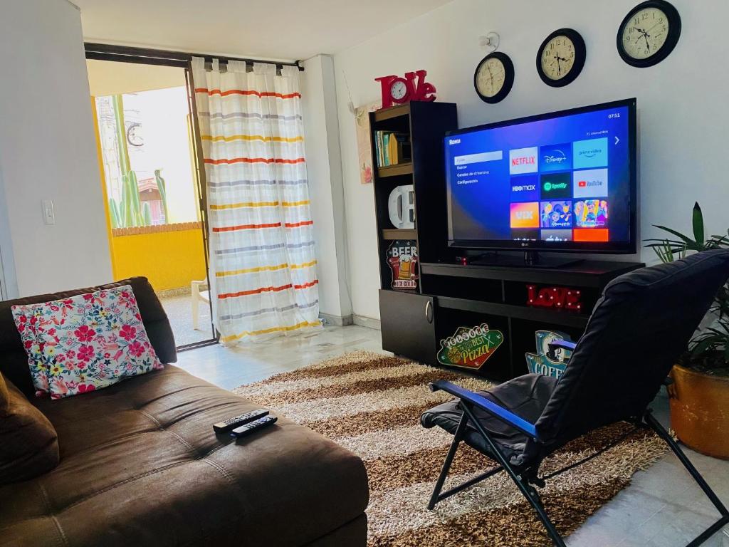 een woonkamer met een bank en een flatscreen-tv bij Apartamento de 4 Habitaciones Éxito de Laureles in Medellín