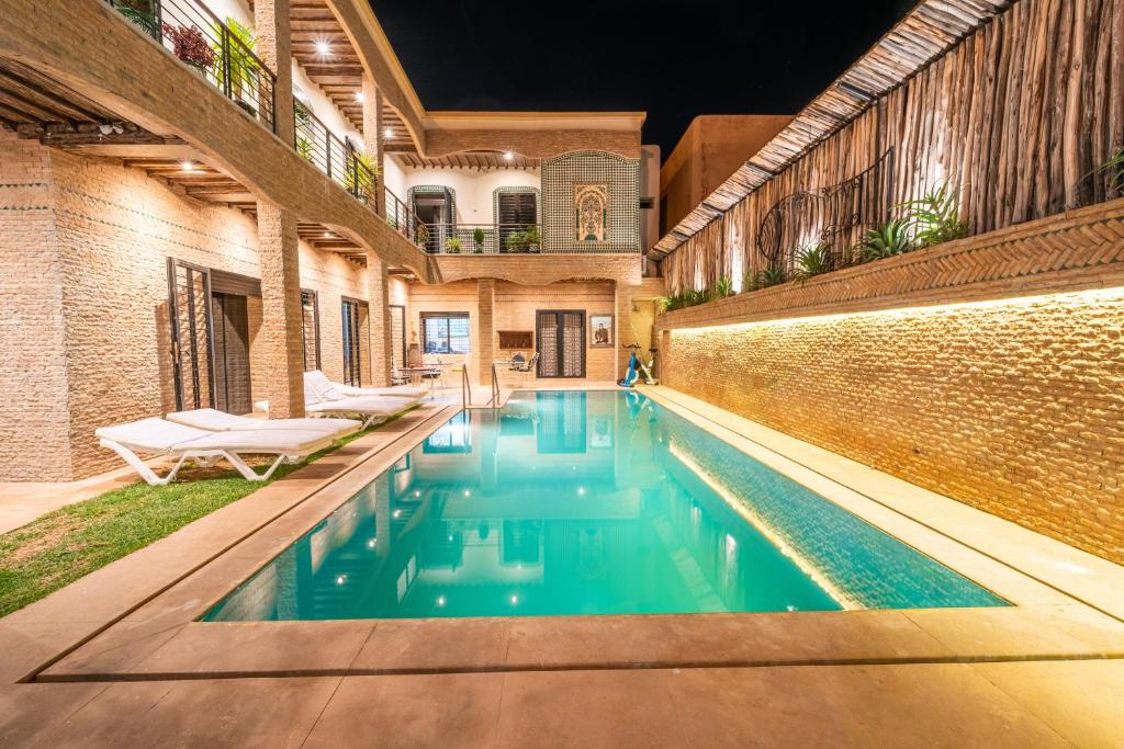 an indoor swimming pool with blue water in a building at Riad Les Nuits De Fès in Fès