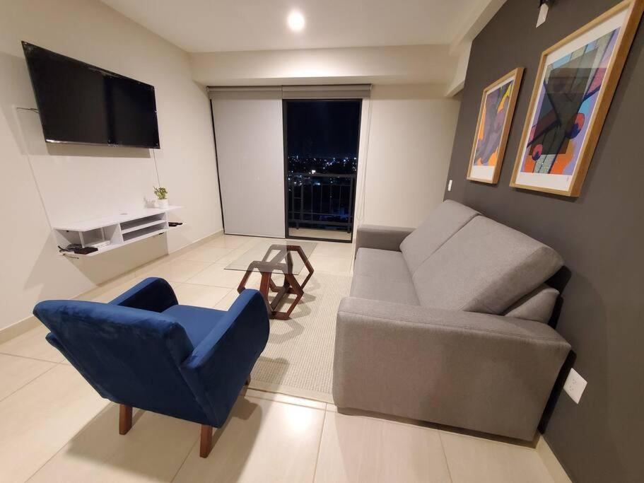 a living room with a couch and a chair and a television at Departamento Puesta del Sol Gdl in Guadalajara