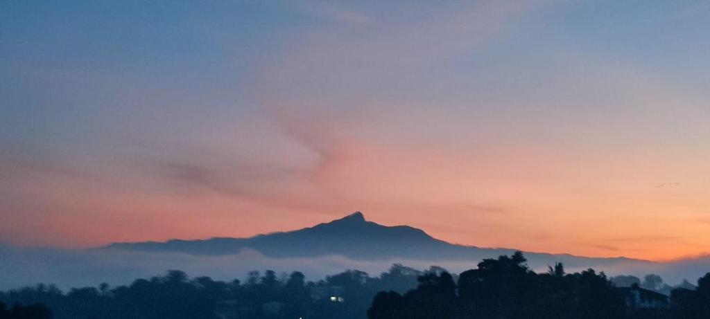 un coucher de soleil avec une montagne en arrière-plan dans l'établissement The Tenthola, à Kandy