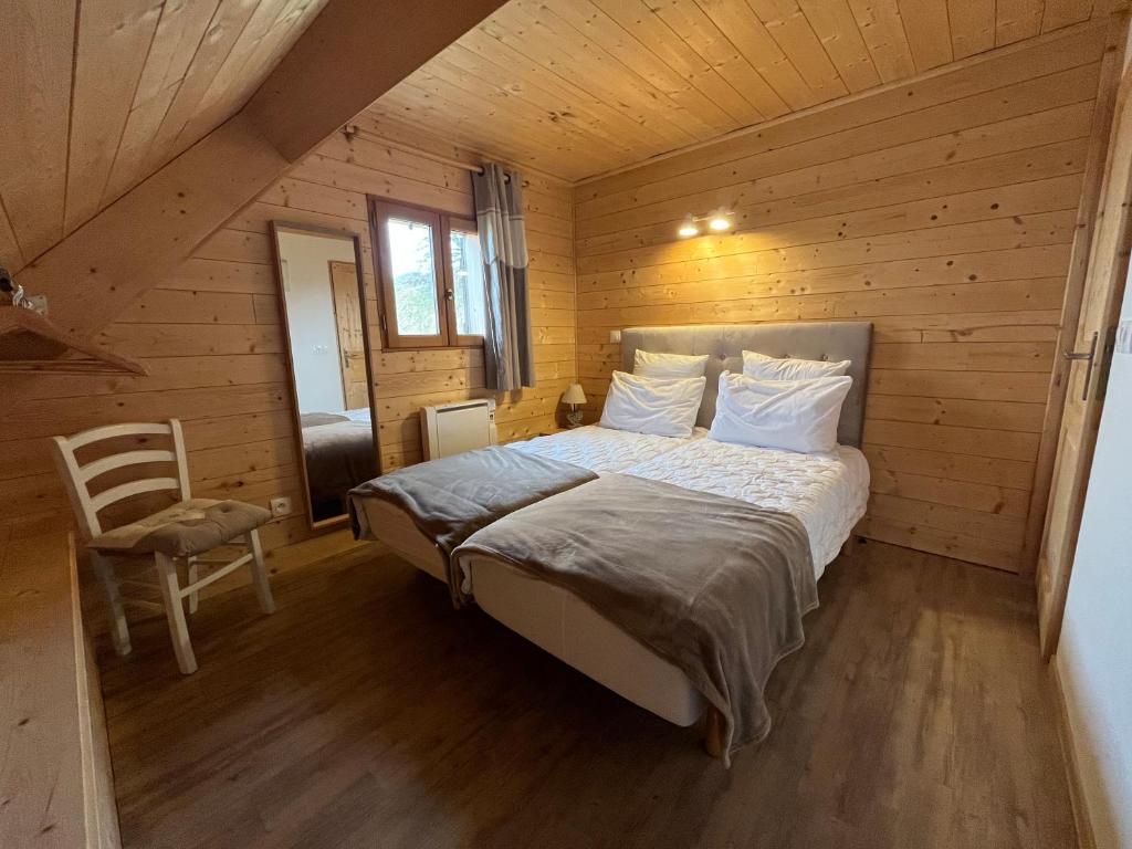 a bedroom with a bed in a wooden cabin at Chalet des Monts Dore in Chastreix