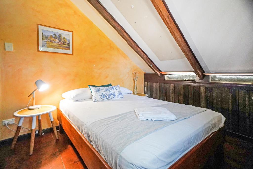 una camera con letto e tavolo con lampada di Woolshed Eco Lodge a Hervey Bay