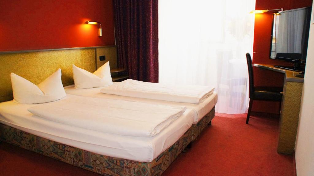 Postel nebo postele na pokoji v ubytování Hotel am Buschkrugpark