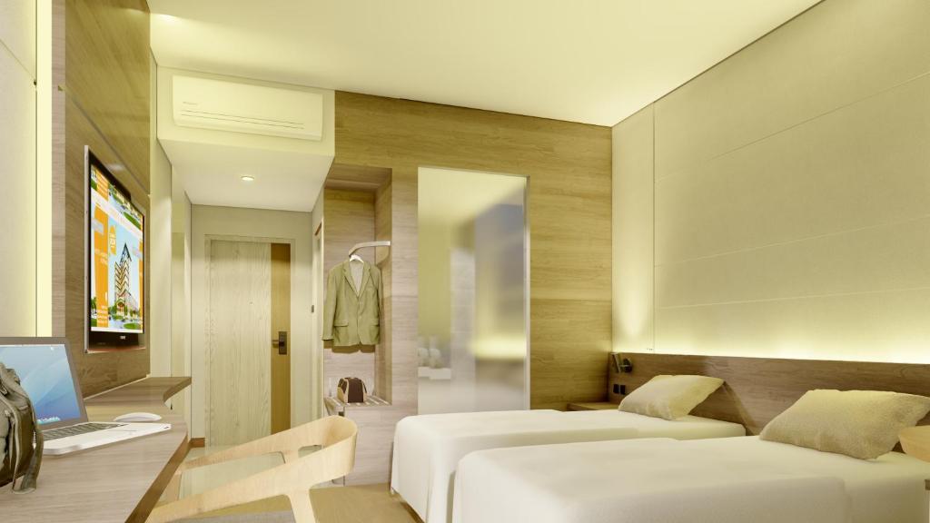 a hotel room with two beds and a desk at Harper Kupang in Kupang