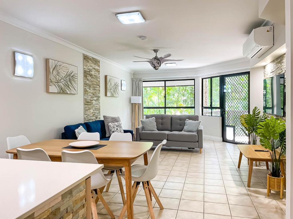 uma sala de estar com uma mesa e um sofá em Trinity Links Resort em Cairns
