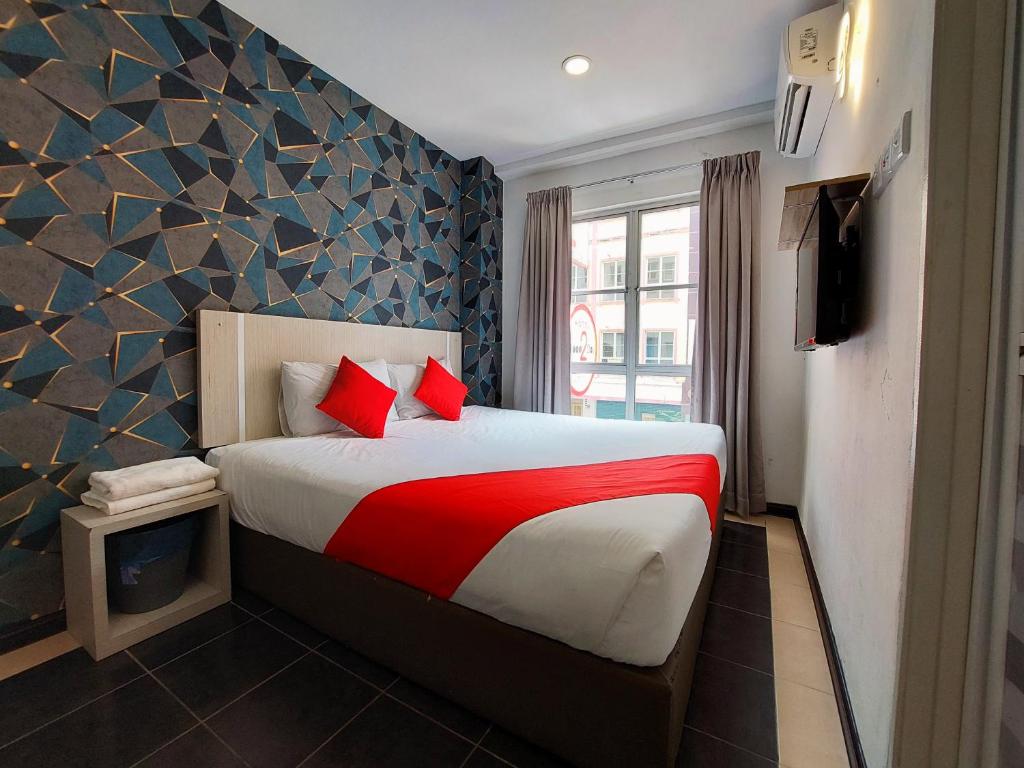 a bedroom with a large bed with red pillows at Good2Stay Budget Hotel in Malacca