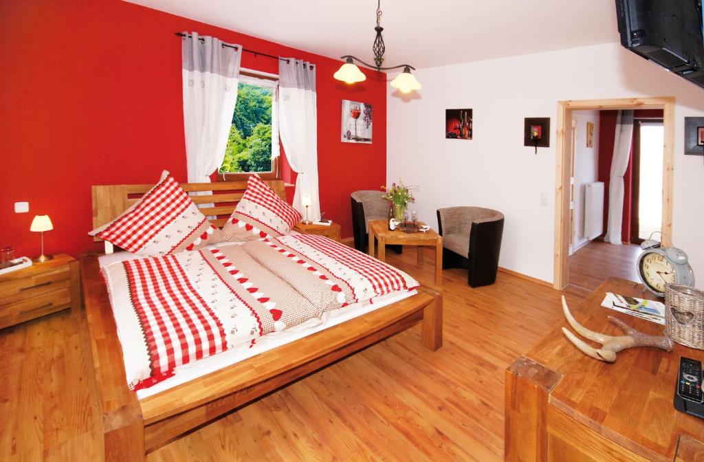 een slaapkamer met een groot bed met rode muren bij Gästezimmer Hans-Norbert Mack in Hallgarten