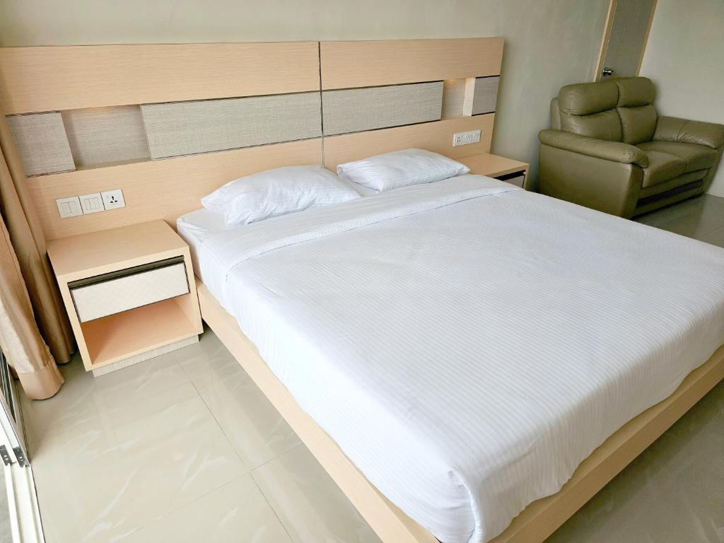 sypialnia z dużym łóżkiem i krzesłem w obiekcie Nagoya thamrin apartment (Favehotel Building) w mieście Nagoja