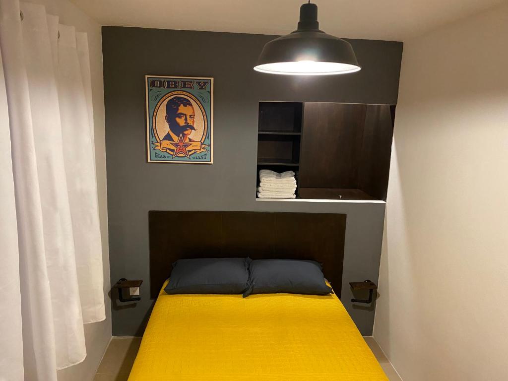 ein Schlafzimmer mit einem Bett mit einer gelben Decke in der Unterkunft Cozy Condesa in Mexiko-Stadt