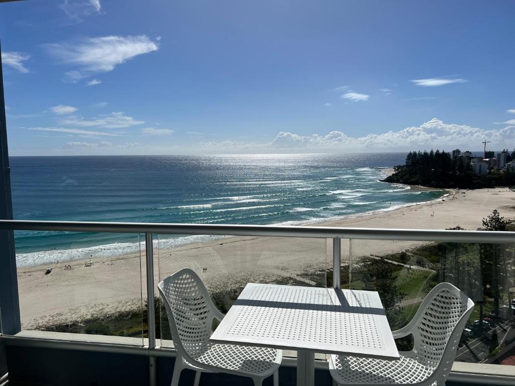 a balcony with a table and chairs and the beach at Endless Summer in Cooly Level 18 in Gold Coast