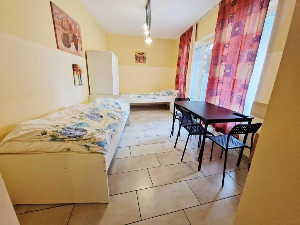 Schlafzimmer mit einem Bett, einem Tisch und Stühlen in der Unterkunft cozy Apartments in Mülheim in Köln