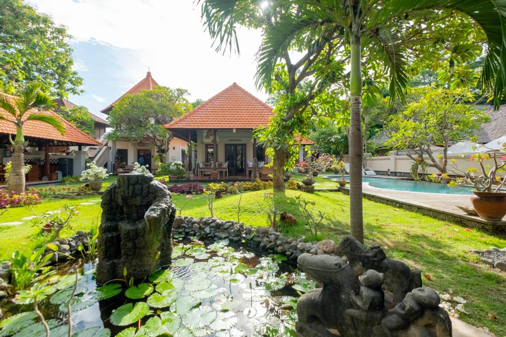 a garden with a pond in front of a house at Villa Santai Pemuteran in Pemuteran