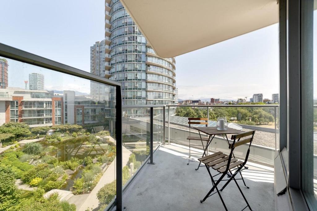 a balcony with a table and chairs on it at GardenView Modern Condo with Parking, Gym, Pool, AC in Vancouver
