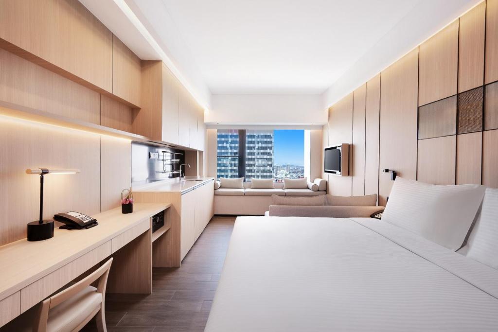 a hotel room with a bed and a couch at Metropolitan Residence in Shanghai