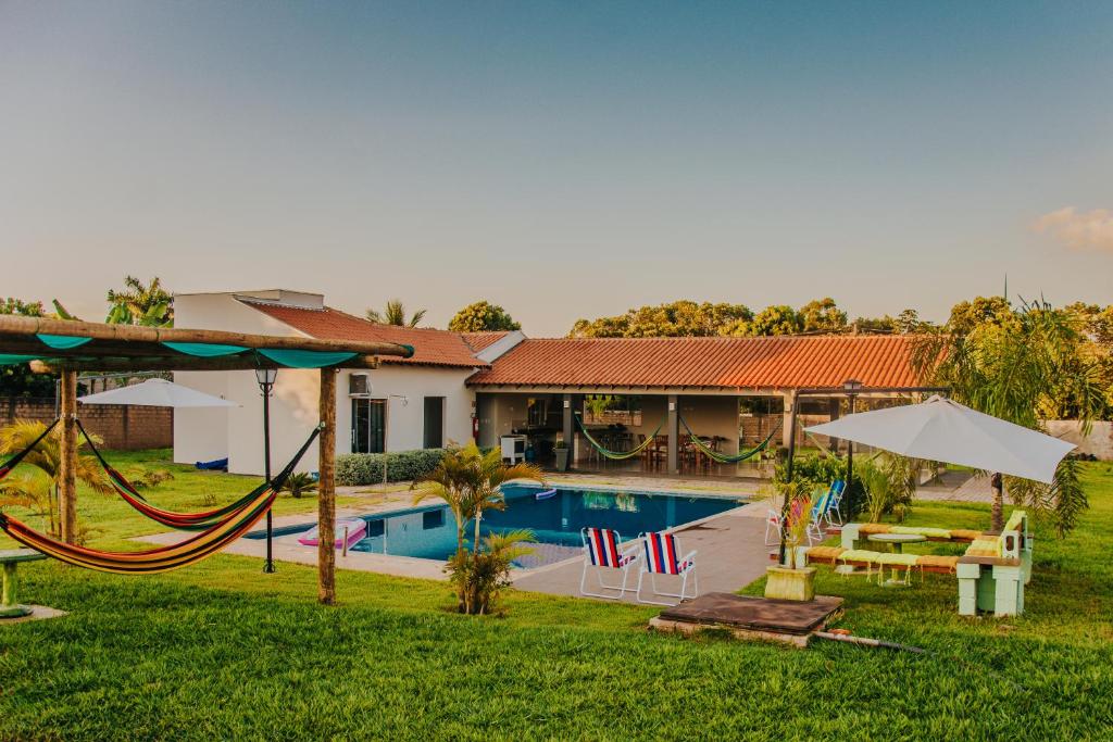 a house with a swimming pool and a playground at Chacara Las Palomas in Presidente Epitácio