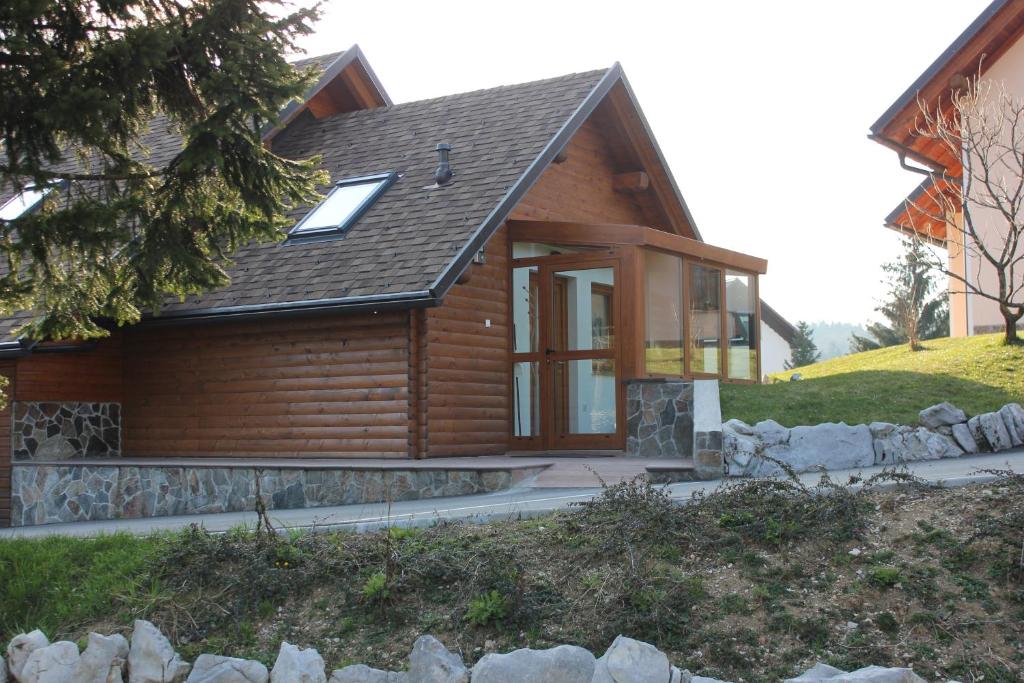 une maison en rondins avec une terrasse couverte et une maison dans l'établissement Charming countryside house, à Lome