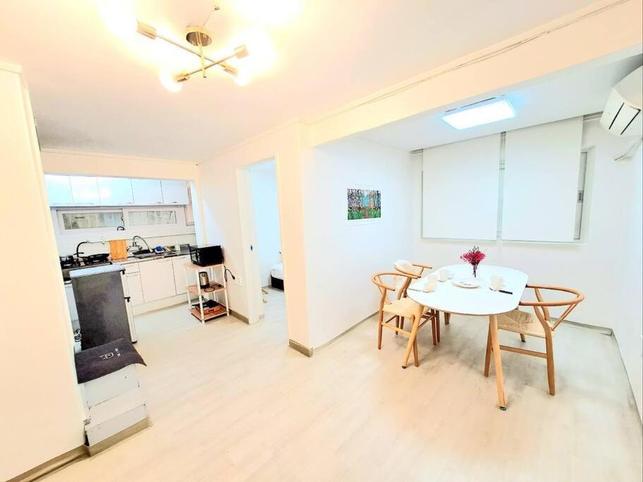 a living room with a table and chairs and a kitchen at Two bedroom Apt Hongik University in Seoul