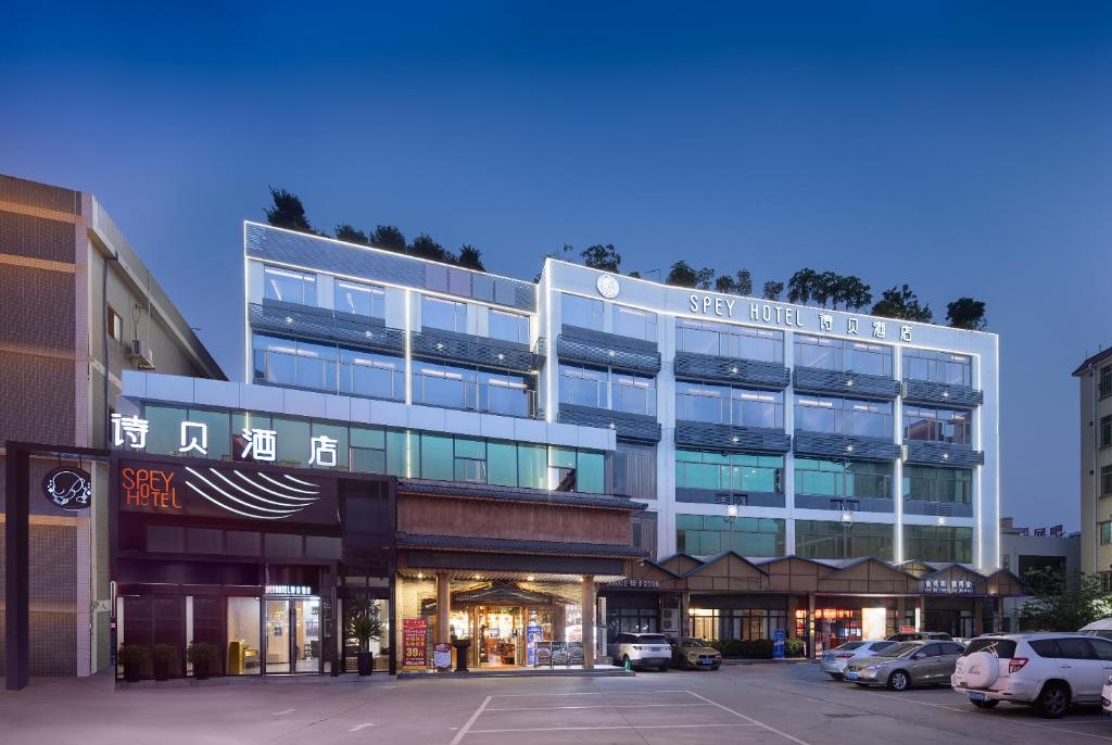 un gran edificio con coches estacionados en un estacionamiento en Spey Hotel en Guangzhou