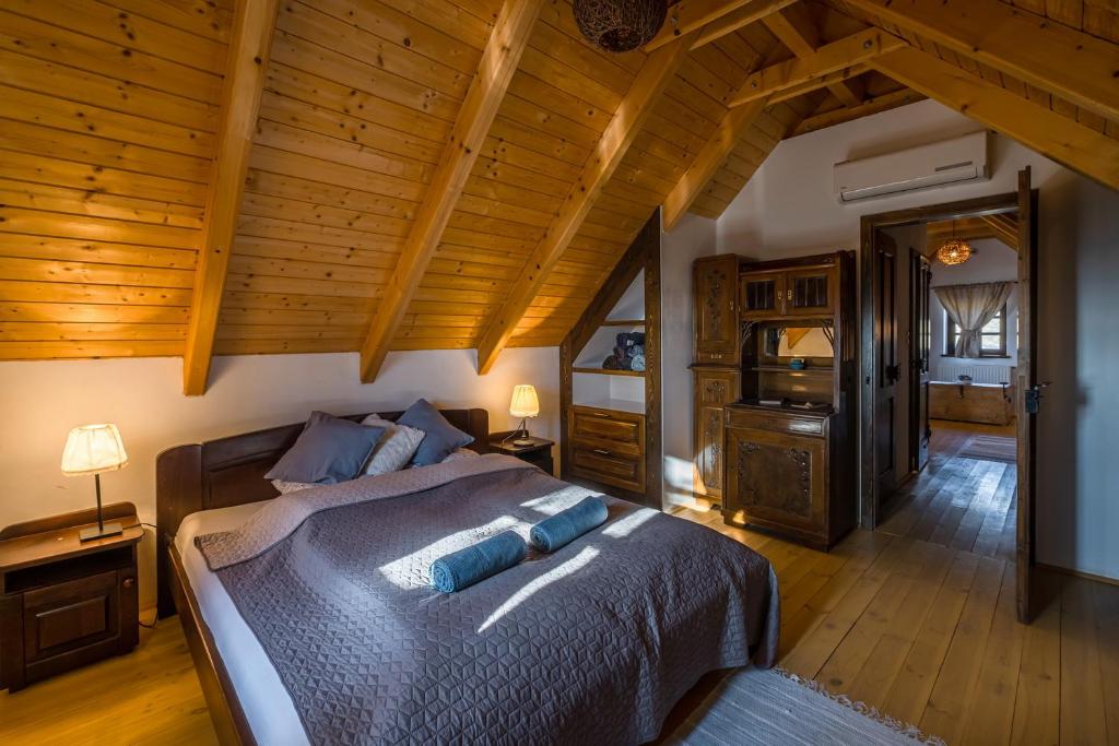 een slaapkamer met een bed en een houten plafond bij Tagyon Birtok Royal Apartmanház in Tagyon