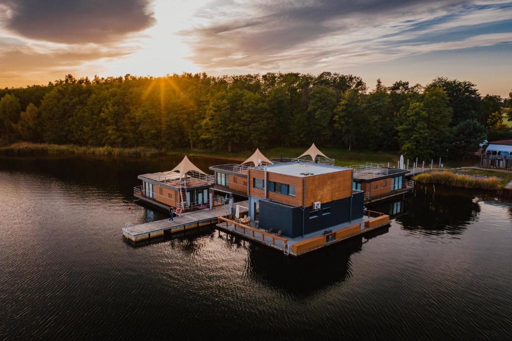 a group of houses on a dock in the water at Schwimmende Ferienhäuser auf dem See - Spreewald in Vetschau