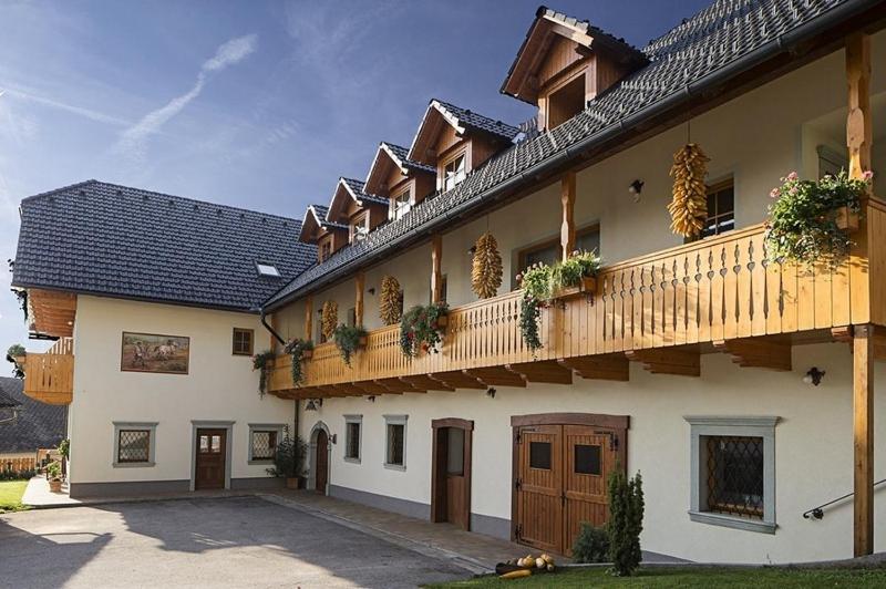 un gran edificio con un balcón con plantas. en Tourist Farm "Pri Biscu" en Bled