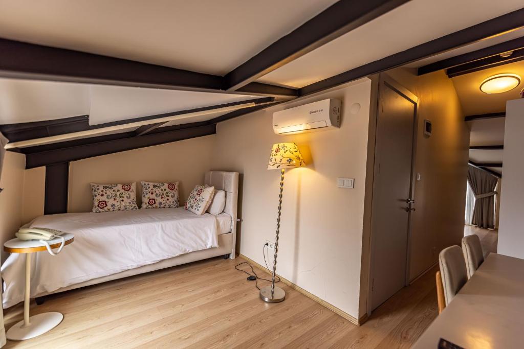 a room with a bed and a lamp and a table at Calanthe Residence in Istanbul