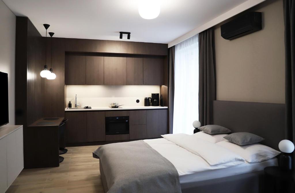 sypialnia z dużym łóżkiem i kuchnią w obiekcie Apartamenty Legionów 40 - A12 w Kaliszu