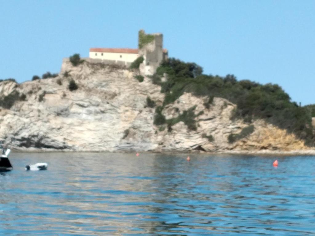 een huis bovenop een heuvel naast het water bij La Casina di Bice-Casa mia in Casa Mora
