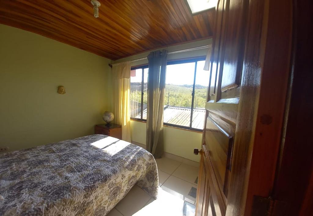 a bedroom with a bed and a large window at CERCA A TODO EN COSTA RICA in San Ramón