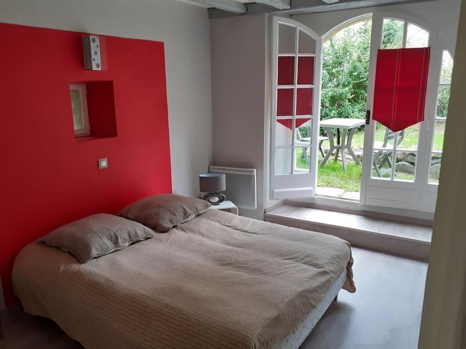 - une chambre avec un mur rouge et un lit dans l'établissement Les 2 p'tits loups, à Osse-en-Aspe