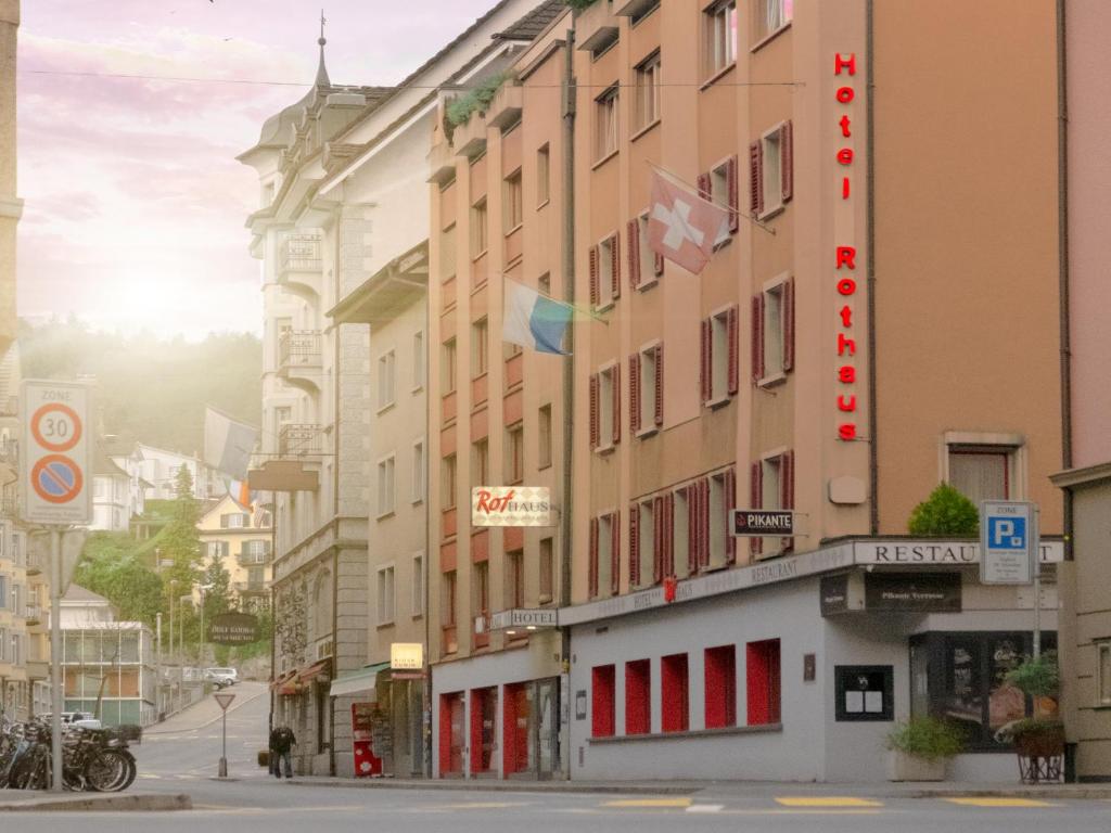 a building with red doors on a city street at Hotel Rothaus Luzern & Peruvian Culinary Art in Luzern