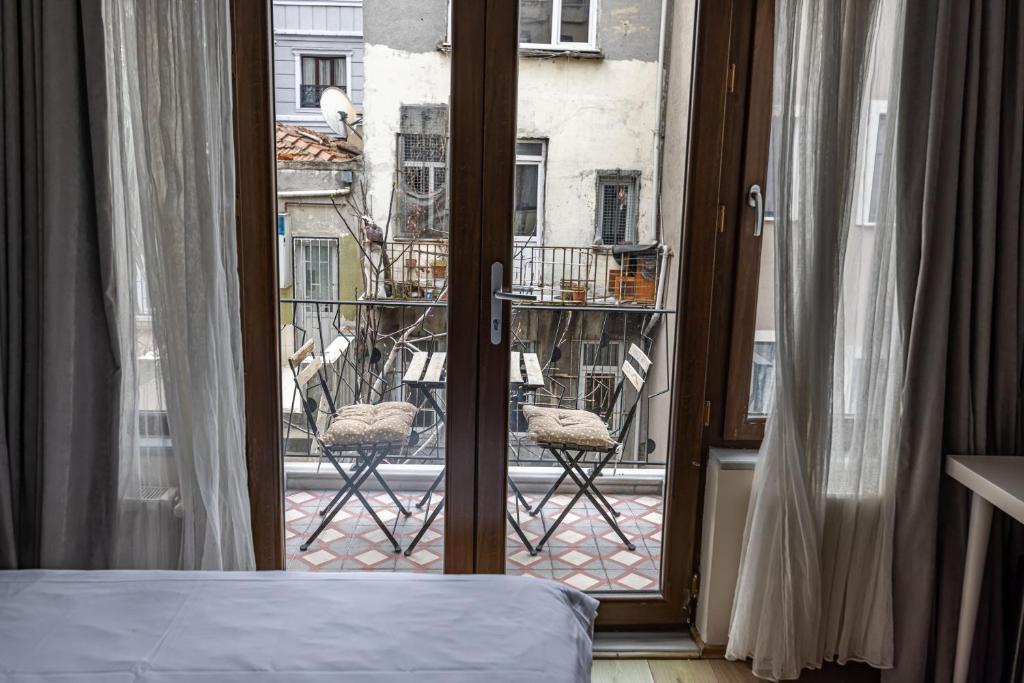 a bedroom with a window with a view of a balcony at Calanthe Residence in Istanbul