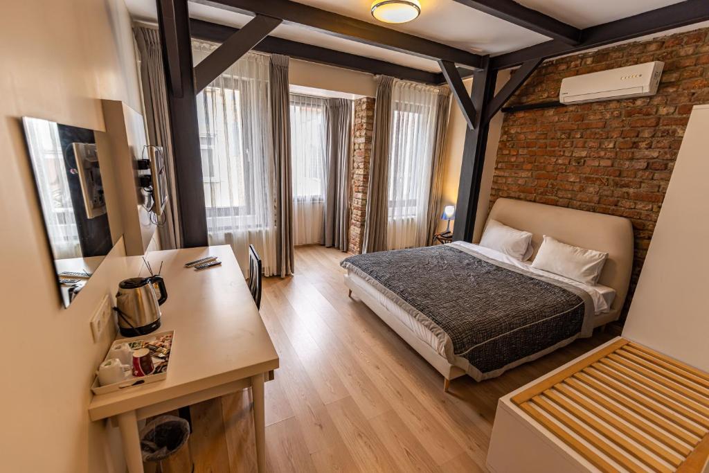 a bedroom with a bed and a brick wall at Calanthe Residence in Istanbul