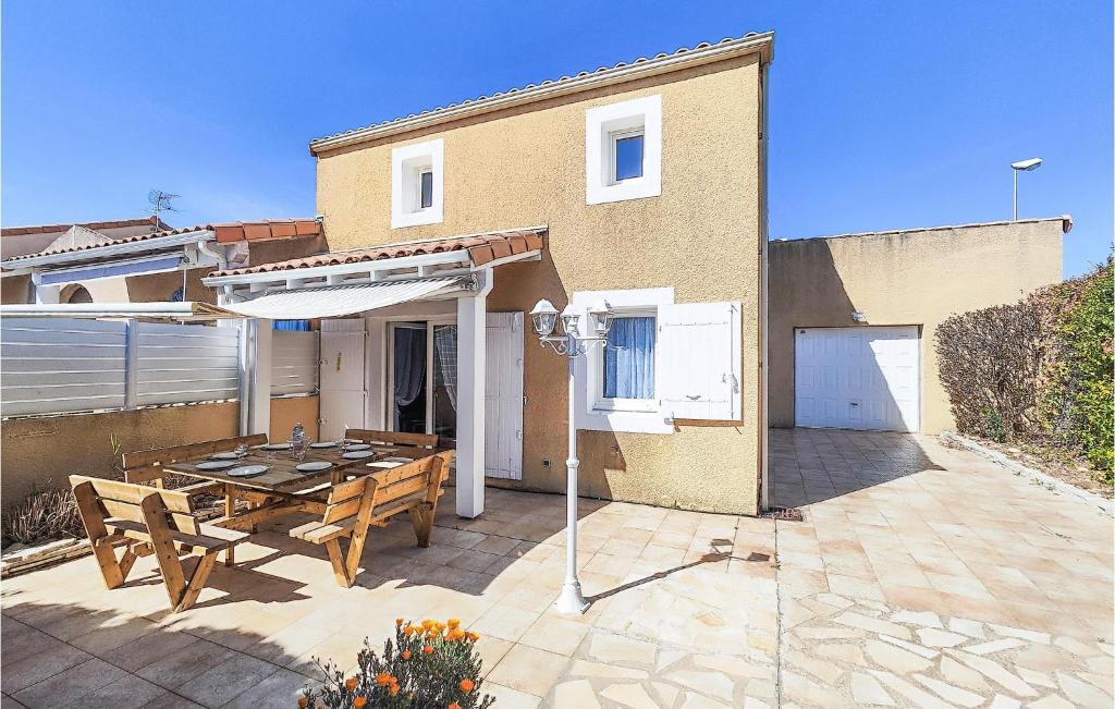 um pátio com uma mesa de madeira e um guarda-chuva em Amazing Home In Portiragnes With Outdoor Swimming Pool em Portiragnes