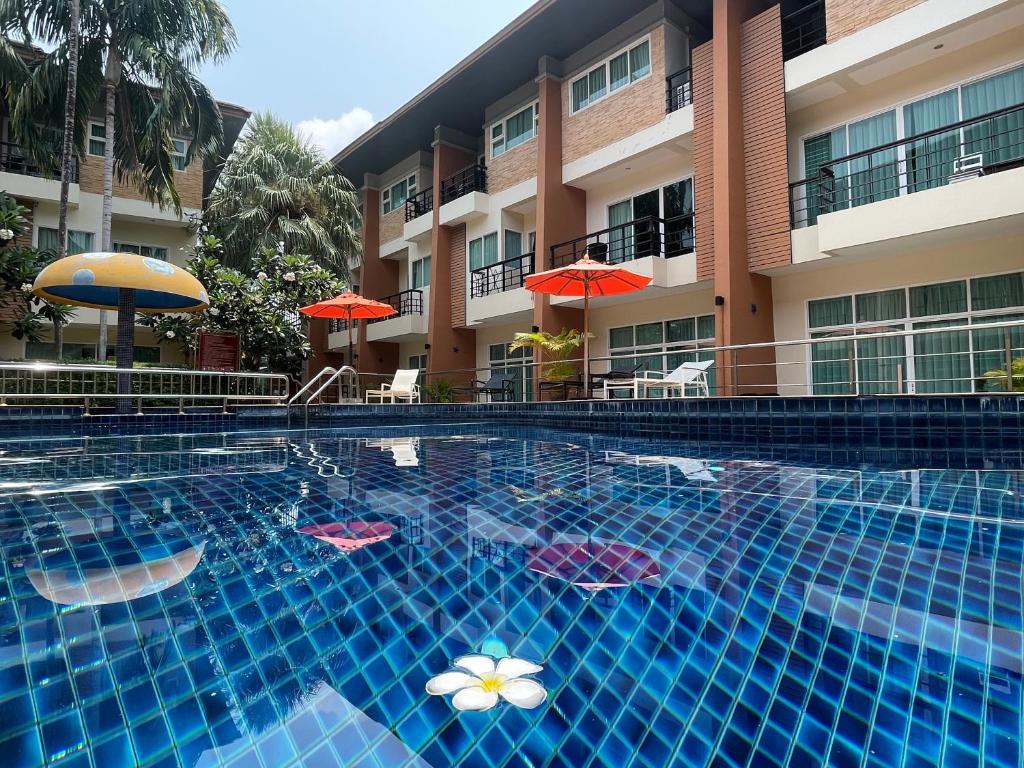 a swimming pool in front of a hotel with umbrellas at Thalassa pool Kata Beach in Kata Beach