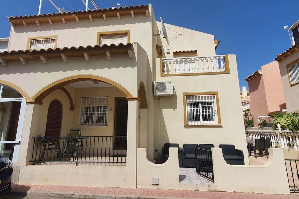 ein Haus mit einer Veranda und einem Balkon in der Unterkunft Casa Marrón, Playa Flamenca in Playa Flamenca