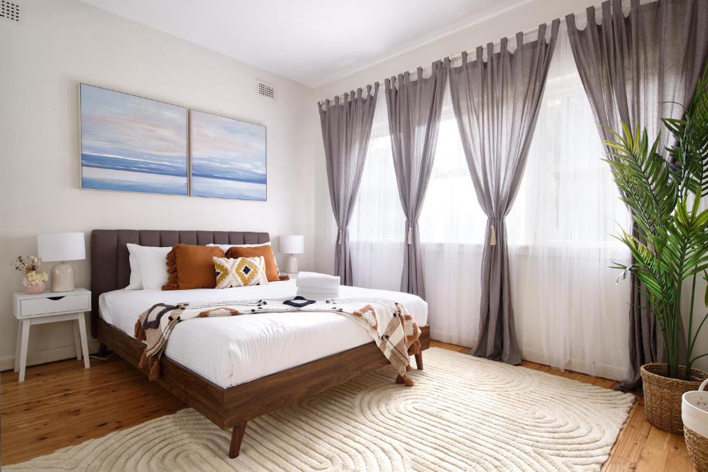 ein Schlafzimmer mit einem Bett und einem Laptop darauf in der Unterkunft JLs Bondi Escape - Walk to beach and Shopping in Sydney