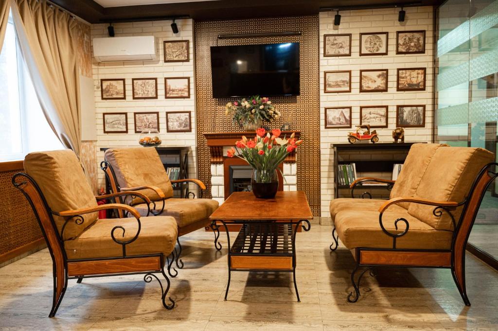 salon z krzesłami, telewizorem i kominkiem w obiekcie UYUTNYY DOM w mieście Taraz