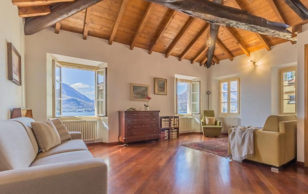a living room with a couch and chairs and windows at Casa Ferrari in Varenna