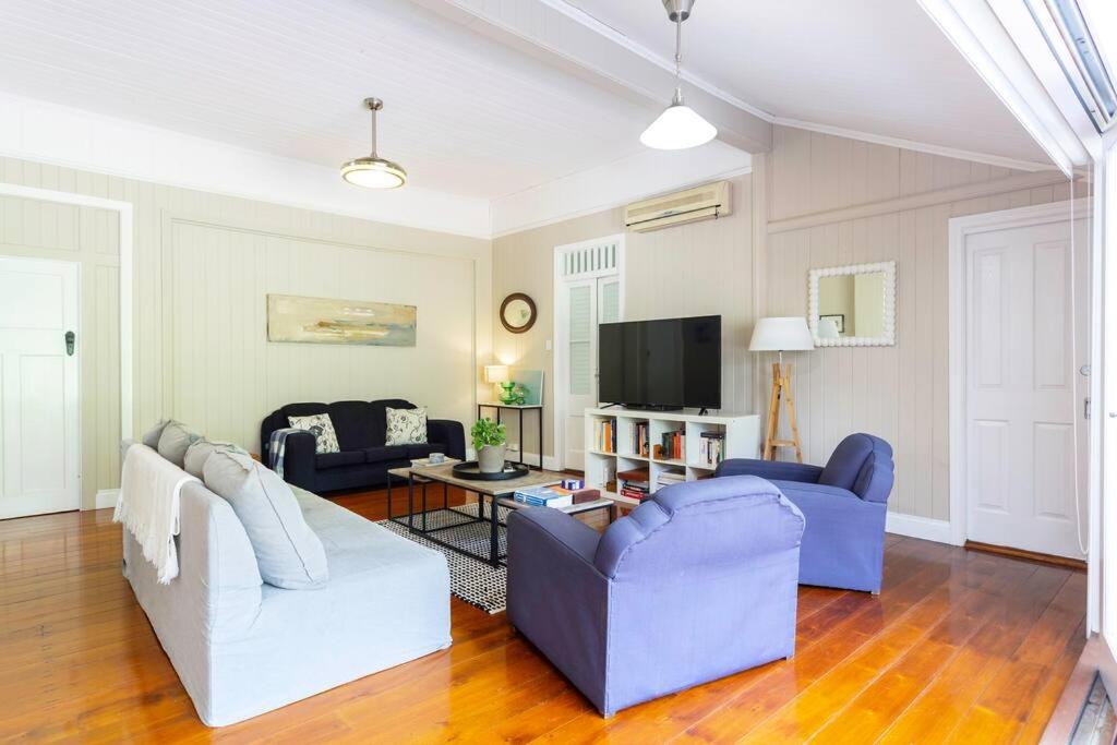 a living room with two couches and a tv at Garden Cottage 1Brm Private & Spacious in Brisbane