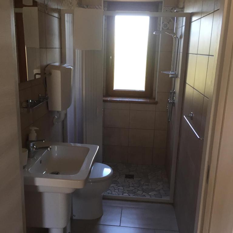 łazienka z umywalką, toaletą i oknem w obiekcie Paraiso w mieście Mafalda