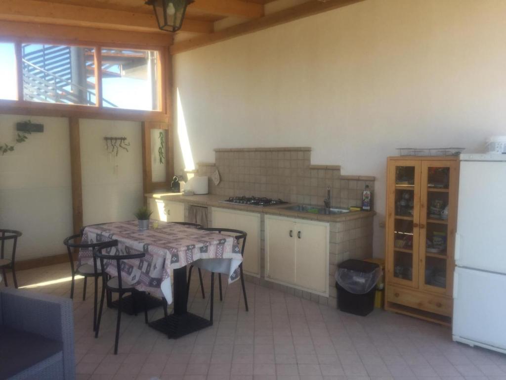 kuchnia ze stołem, krzesłami i lodówką w obiekcie Paraiso w mieście Mafalda