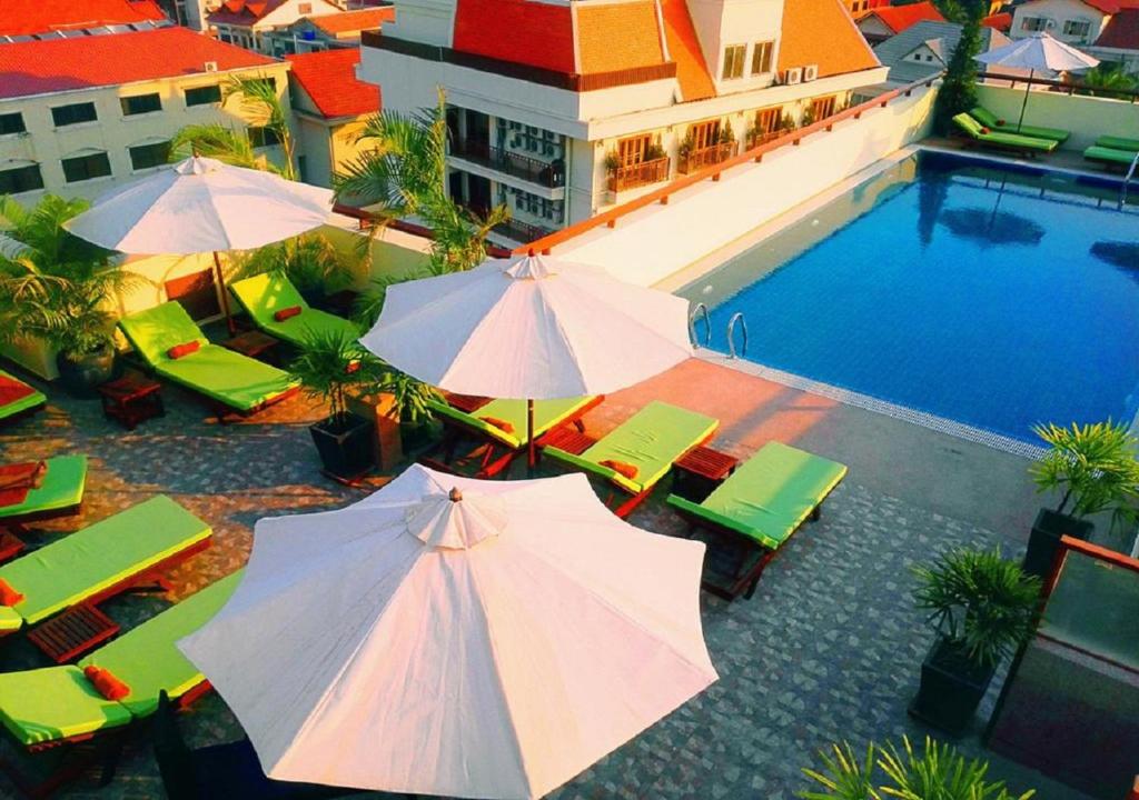 an overhead view of a pool with umbrellas and tables and chairs at Cheathata CTA Hotel Siem Reap in Siem Reap