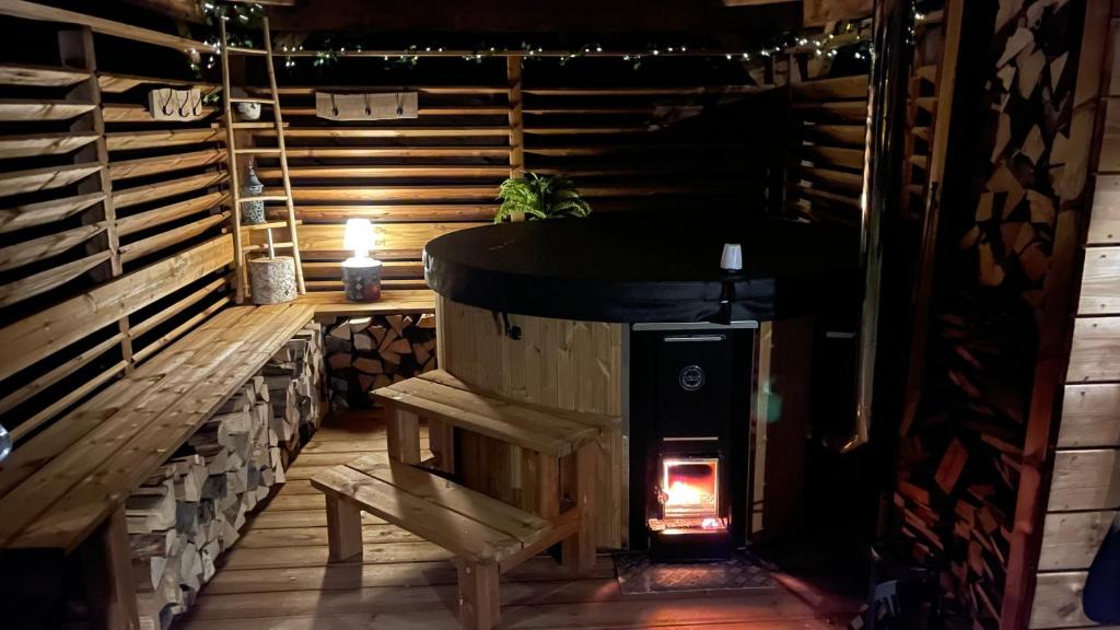 a wood stove in a room with a bench at ※ Résidence POMME DE PIN - Terrasse - Nature ※ in Xonrupt-Longemer