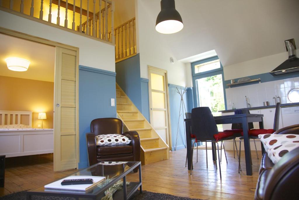 un salon avec une table et des chaises et un escalier dans l'établissement Le grenier du Faouët, à Le Faouët